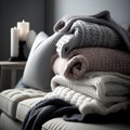 A stack of warm knitted sweaters on a sofa in the living room