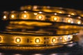 A stack of warm white LED lightson coiled flexible lighting strips, selective focus.