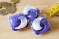 Stack of washing capsules and some coins