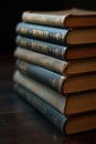 A stack of weathered, leather bound antique books on a dusty wooden surface A stack of several antique, leather bound books with Royalty Free Stock Photo
