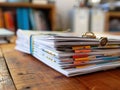 Stack of organized documents with tabs and clip on a wooden desk environment Royalty Free Stock Photo
