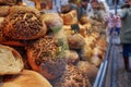 Stack of wheat and rye breads with whole grain meal and rustic mustard crust at the front of bakery store.