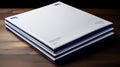 a stack of white and blue folders sitting on top of a wooden table