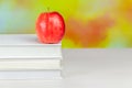Stack of white books with juicy fresh apple on desktop over blurry autumn background. Back to school Royalty Free Stock Photo