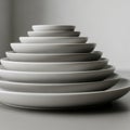 A stack of white ceramic plates is arranged in a pyramid, from Royalty Free Stock Photo