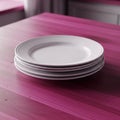 A stack of white ceramic plates sits neatly on a vibrant pink wooden table Royalty Free Stock Photo