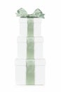 Stack of white Christmas gift boxes with frosty green bow and ribbon isolated on white