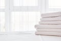 Stack of white clean bath towels on bed sheet in modern hotel bedroom interior with window on background, copy space Royalty Free Stock Photo