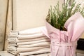 Stack of white clean rhinestones behind flowerpot with heather in pink paper with ribbon in the foreground.