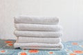 Stack of white clean towels on white background. Ironing clothes on ironing board. Stack of clean towels on table. Royalty Free Stock Photo