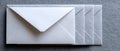 Stack of white envelopes arranged in a neat row on a textured gray surface with one envelope prominently on top Royalty Free Stock Photo