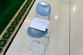 A stack of white envelopes placed on a gray folding chair inside a mosque Royalty Free Stock Photo