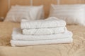 Stack of white hotel towel on bed in bedroom interior. Royalty Free Stock Photo