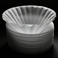A stack of white paper coffee filters is neatly arranged in a pile, with one filter slightly Royalty Free Stock Photo
