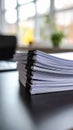 Stack of white paper documents held together with black binder clips on a desk Royalty Free Stock Photo