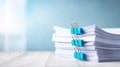 Stack of white paper documents secured with blue binder clips for business organization and administration themes Royalty Free Stock Photo