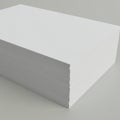Stack of white paper sheets neatly piled on a flat, gray surface. The sheets have sharp Royalty Free Stock Photo