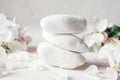 Stack of white pebble stones on light plaster surface, with apple flowers Royalty Free Stock Photo