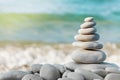 Stack of white pebbles stone against blue sea background for spa, balance, meditation and zen theme.