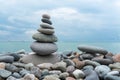 Stack of white pebbles stone against blue sea background for spa, balance, meditation and zen theme Royalty Free Stock Photo