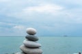 Stack of white pebbles stone against blue sea background for spa, balance, meditation and zen theme Royalty Free Stock Photo