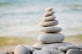 Stack of white pebbles stone against sea background for spa, balance, meditation and zen theme.