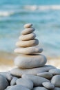 Stack of white pebbles stone against sea for spa, balance, meditation and zen theme. Royalty Free Stock Photo