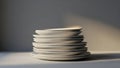 A stack of white plates is illuminated by sunlight in a minimalist scene Royalty Free Stock Photo
