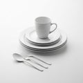 Stack of White Plates with Mug and Cutlery on White Background dishes dinnerware Royalty Free Stock Photo