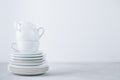 Stack of white porcelain plates and cups on gray stone background Royalty Free Stock Photo