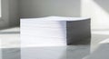 Stack of white printer paper on a marble surface under soft natural light, casting Royalty Free Stock Photo