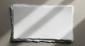 A stack of white, rectangular sheets of torn-edged paper lies on a smooth, gray Royalty Free Stock Photo