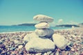 Stack of white stones balancing on the pebbly beach; retro Royalty Free Stock Photo