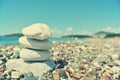 Stack of white stones balancing on the pebbly beach; retro Royalty Free Stock Photo