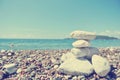 Stack of white stones balancing on the pebbly beach; retro Royalty Free Stock Photo
