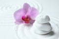 Stack of white stones and flower on sand with pattern. Zen, meditation, harmony Royalty Free Stock Photo