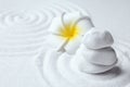 Stack of white stones and flower on sand with pattern. Zen, meditation, harmony Royalty Free Stock Photo