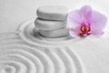 Stack of white stones and flower on sand with pattern. Zen, meditation, harmony Royalty Free Stock Photo