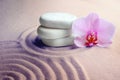 Stack of white stones and beautiful flower on sand with pattern. Zen, meditation, harmony Royalty Free Stock Photo