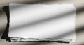 A stack of white, torn-edged paper situated on a flat surface. Sunlight casts diagonal Royalty Free Stock Photo