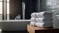 A stack of white towels on a table in a white Scandinavian style bathroom against a background of blurred green Royalty Free Stock Photo