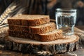 Stack of Whole Grain Bread with Seeds on Rustic Wooden Table beside a Clear Glass of Water Royalty Free Stock Photo