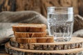 Stack of Whole Grain Bread with Seeds on Rustic Wooden Table beside a Clear Glass of Water Royalty Free Stock Photo