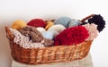 Stack of knitted hats and yarns in a basket