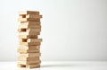Stack of wooden blocks forming a tower on white background. Jenga game pieces arranged in a precarious structure. Wooden bricks Royalty Free Stock Photo