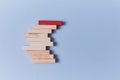 Stack of wooden blocks with red plank on top. Not like everyone. Uniqueness and originality. Stand out from the crowd Royalty Free Stock Photo