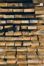 A stack of wooden boards close-up. The texture of the ends of wooden boards