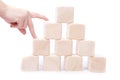 Stack wooden cubes.Hand establishes block tower isolated. Royalty Free Stock Photo