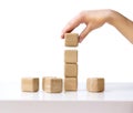 Stack wooden cubes.Hand establishes block tower isolated. Royalty Free Stock Photo