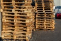 A stack of wooden pallets in an internal warehouse. An outdoor pallet storage area under the roof next to the store. Piles of Euro